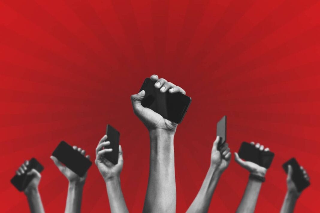 Group,Of,People's,Hands,Holding,Phones,And,Rising,Them,Up